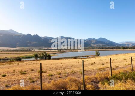 Vista panoramica di una diga di fattoria e le montagne tra Villersdorp e Worcester al tramonto, Overberg, Capo Occidentale, Sud Africa Foto Stock