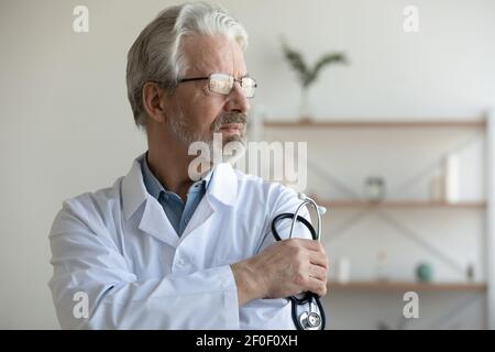 Pene medico maschile maturo guardare a distanza pensare Foto Stock