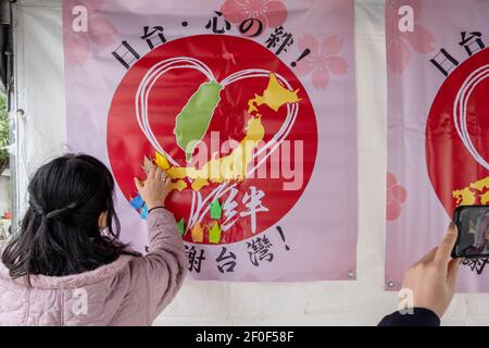 New Taipei, Taiwan. 07 marzo 2021. Un membro del 'Comitato Arigatou Taiwan' mette su una parete gru di carta origami durante la cerimonia di inaugurazione di un monumento che rappresenta i legami amichevoli dei paesi. Quest'anno è il decimo anniversario del terremoto del Giappone dell'Est 311. Nel 2011, il governo e il settore privato di Taiwan hanno donato 25 miliardi di yen (quasi 240 milioni di dollari, la maggior parte del mondo) e inviato squadre di salvataggio in Giappone. Credit: SOPA Images Limited/Alamy Live News Foto Stock