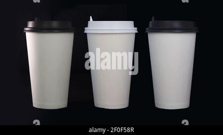 Tre tazze da caffè monouso su sfondo nero Foto Stock