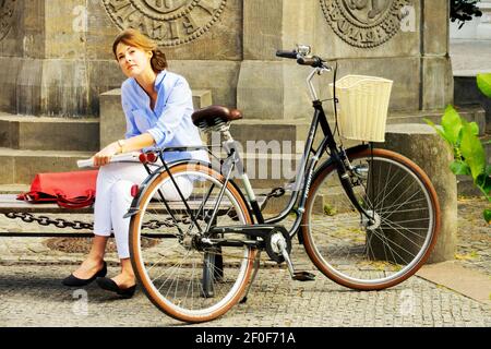 Berlino donna bicicletta nel piccolo quartiere turistico Nikolaiviertel Berlino Germania donna bicicletta Foto Stock