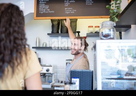 Uomo gioioso che punta con la mano al menu Foto Stock