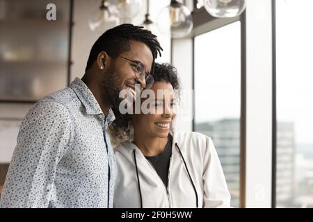 Primo piano sorridente coppia afroamericana abbracciando, visualizzando il buon futuro Foto Stock