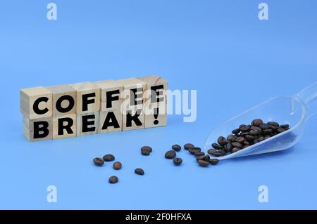 Disposizione dei chicchi di caffè su una paletta e cubo di legno con pausa CAFFÈ testo!. Concetto aziendale. Punti di messa a fuoco selettivi. Foto Stock