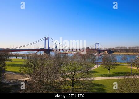 Duisburg, Germania - 1 marzo. 2021: Vista sul verde pensinsula pascolo (Mühlenweide) sul fiume reno sul ponte Friedrich Ebert contro il cielo blu in winte Foto Stock