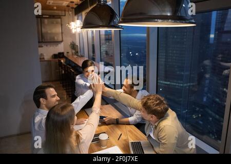 Vista dall'alto, dipendenti diversi che offrono cinque persone in occasione di una riunione tardiva Foto Stock