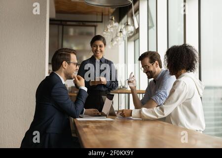Felici e diversi colleghi che si divertono durante una riunione aziendale, ridendo Foto Stock