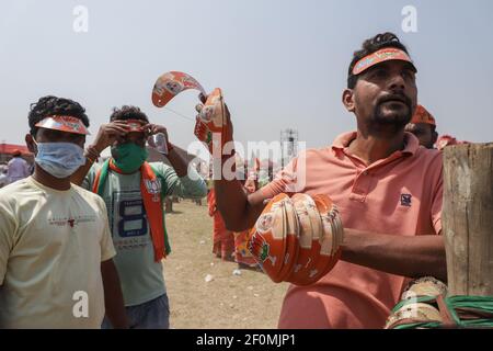 Kolkata, India. 07 marzo 2021. Un uomo vende i cappucci stampati del simbolo del BJP (Bhartiya Janta Party) durante il mega rally brigata.i sostenitori del Bharatiya Janata Party (BJP) hanno tenuto un raduno di massa e una campagna politica prima delle elezioni dell'assemblea legislativa dello stato nel campo della parata brigata a Kolkata. Anche il primo ministro indiano Narendra modi si è Unito alla campagna. Credit: SOPA Images Limited/Alamy Live News Foto Stock