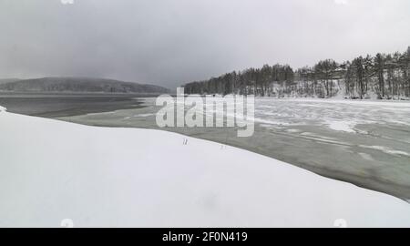 Lago Vlasina in buia, nuvoloso, giorno d'inverno con molta neve. Fotografia di paesaggio. Foto Stock