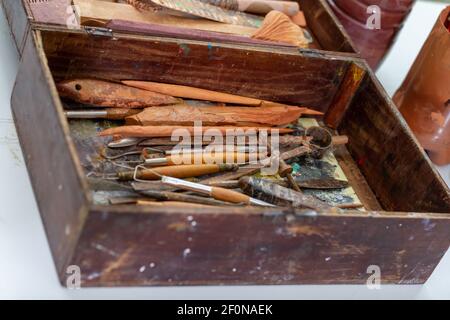 Concetto di arte. Strumenti utilizzati per modellare la scultura. Scatola con vari strumenti e oggetti che sono utilizzati per modellare sculture con resti di argilla. Foto Stock