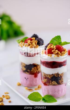 Pannacotta con frutti di bosco, yogurt greco e muesli. Colazione sana Foto Stock
