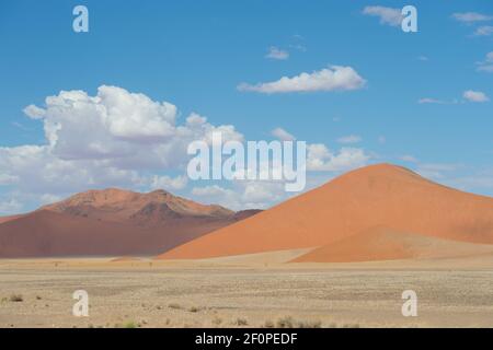 Paesaggio desertico di Sossusvlei in Namibia Africa dune di sabbia rossa con cielo blu e nuvole bianche in formato orizzontale per tipo regola dello spazio aperto dei terzi Foto Stock