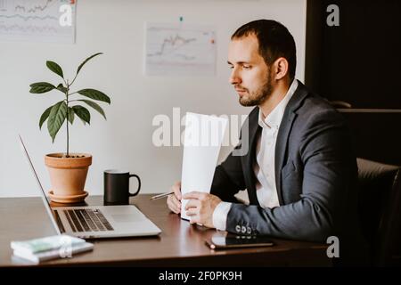 uomo d'affari concentrato che lavora su un computer portatile in ufficio Foto Stock