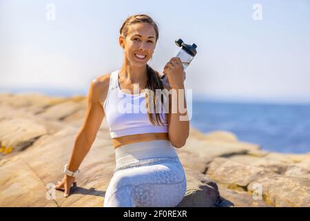 Atleta femminile che riposa dopo l'allenamento all'aperto Foto Stock