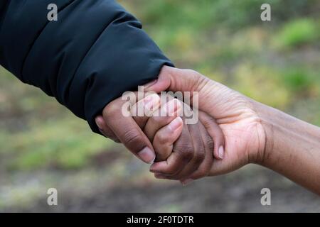 Una donna somala fuggita in Germania tiene la mano del suo figlio di otto anni, che ha potuto riportare in Germania dopo mesi di separazione Foto Stock