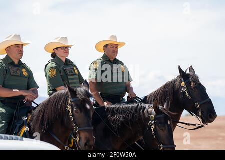 Il presidente Donald Trump parla con i funzionari della polizia di frontiera degli Stati Uniti venerdì 5 aprile 2019 durante la sua ispezione del nuovo muro di sostituzione della frontiera a Calexico Calif. Foto Stock