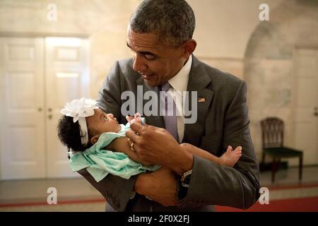 Il presidente Barack Obama tiene la bimba di ex membri del personale Darienne Pagina Rakestraw e Londra Rakestraw nel Piano Terra corridoio della Casa Bianca, 1 luglio 2014. Foto Stock