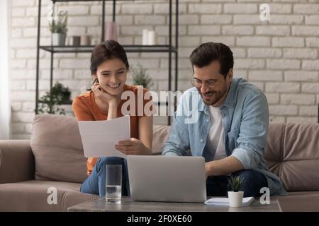 La coppia sposata felice gestisce la contabilità di affari di famiglia all'ufficio domestico Foto Stock