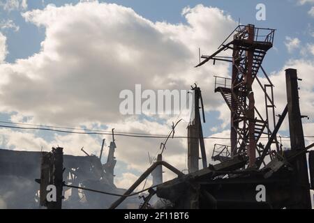 Distrutto edificio industriale dopo il fuoco, concetto di guerra, fumo, rovine Foto Stock