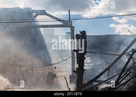 Disastro tecnologico, incendio, edificio industriale distrutto, fumo Foto Stock
