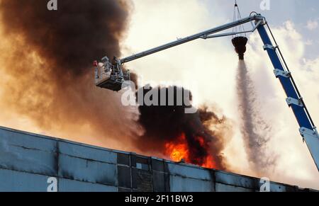 Estinguente, vigile del fuoco nel fumo, getto d'acqua, motore antincendio, elicottero antincendio Foto Stock