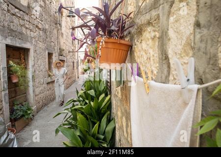 Bella giovane viaggiatore bionda con cappello di paglia e godersi una vacanza estiva in una vecchia città costiera dell'Adriatico