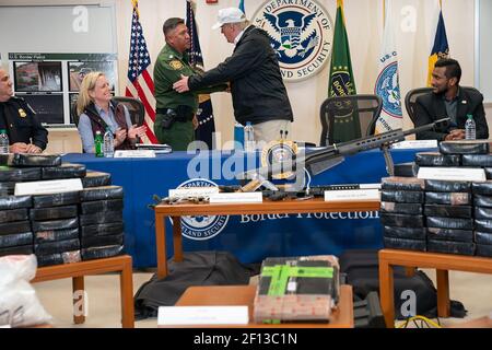 Il presidente Donald Trump partecipa a una tavola rotonda sull'immigrazione e la sicurezza delle frontiere giovedì 10 2019 gennaio presso la stazione McAllen di McAllen, Texas. Una tabella di contrabbando sequestrato dagli agenti di polizia di frontiera degli Stati Uniti che include armi droghe illegali e sacchetti di contanti sono visti in mostra. Foto Stock