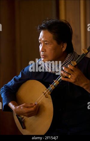 Musicisti vietnamiti che suonano un liuto lunare, Can Tho, Mekong Delta, Vietnam del Sud. Il đàn nguyệt chiamato anche nguyệt cầm, đàn kìm, è uno strumento musicale tradizionale vietnamita a due corde. Foto Stock