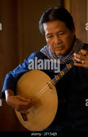 Musicisti vietnamiti che suonano un liuto lunare, Can Tho, Mekong Delta, Vietnam del Sud. Il đàn nguyệt chiamato anche nguyệt cầm, đàn kìm, è uno strumento musicale tradizionale vietnamita a due corde. Foto Stock