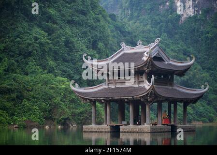 Una pagoda nel fiume del complesso Trang An Scenic Landscape, Ninh Binh, Vietnam. Foto Stock