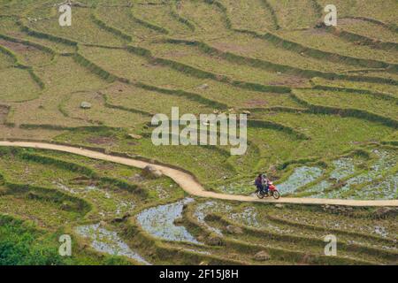 Paesaggio rurale che circonda Sapa, Laos Cai Provincia, nord Vietnam. Coppia di un mtorcycle guidando lungo i campi di riso terrazzati. Foto Stock