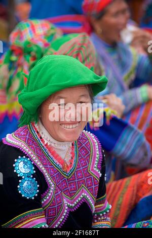 Sorridente donna vietnamita in abbigliamento in stile Hmong Flower al mercato di Bac ha, provincia di Lao Cai, Vietnam nord-orientale Foto Stock