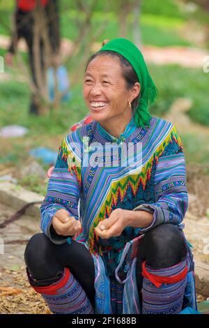 Sorridente donna vietnamita in abbigliamento in stile Hmong Flower al mercato di Bac ha, provincia di Lao Cai, Vietnam nord-orientale Foto Stock