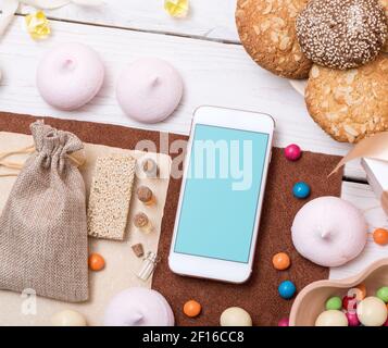 Un mock-up di smartphone tra i dolci Foto Stock