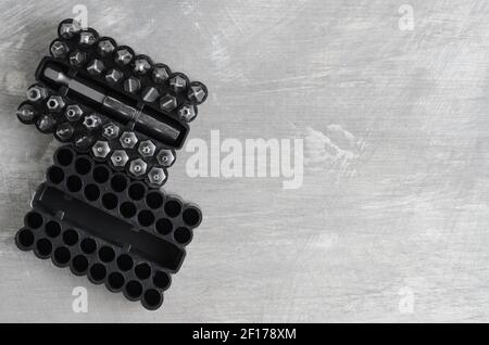 Punte per cacciaviti per vari standard in un pratico contenitore su fondo in cemento grigio. Messa a fuoco selettiva. Foto Stock