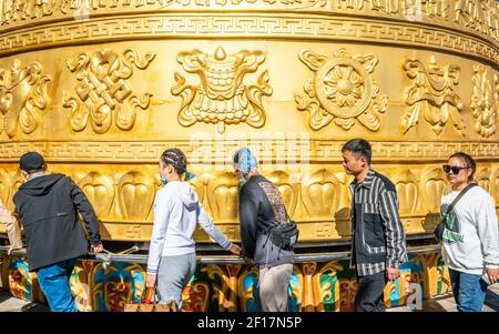 Shangrila Cina, 8 ottobre 2020 : molti turisti che girano la ruota di preghiera buddista gigante tibetana del tempio di Dafa nel centro storico di Dukezong a Shangri-la Foto Stock