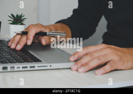 Mano dell'uomo che usa la tastiera del computer portatile. Cerca in internet, informazioni, social networks.Businesses che commerciano acquisti online. Foto Stock