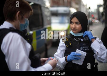 Un ufficiale di polizia femminile parla alla sua radio durante una sosta e una ricerca a London Bridge durante un'operazione tutta femminile da parte della polizia metropolitana, la prima del suo genere per la forza, in occasione della Giornata internazionale della donna. Data immagine: Sabato 6 marzo 2021. Foto Stock