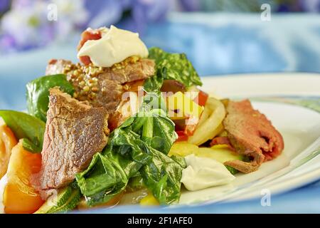 Insalata di carne con pomodori verdi su fondo piatto blu molte ricette alimentari Foto Stock
