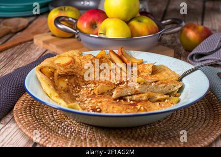 Pancake di riso con mele smaltate, mandorle tostate e cannella su un piatto Foto Stock