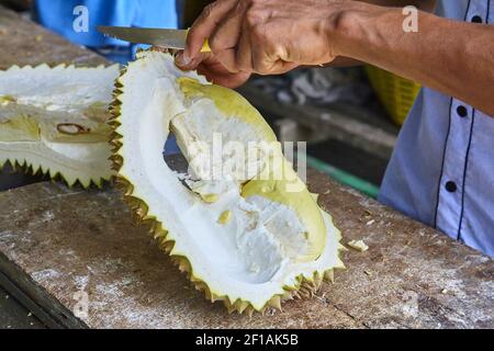 L'uomo pulisce il mercato di frutta esotica durian in Thailandia Foto Stock