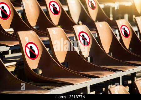 Sedili con segnali di divieto. La distanza sociale durante gli eventi pubblici Foto Stock