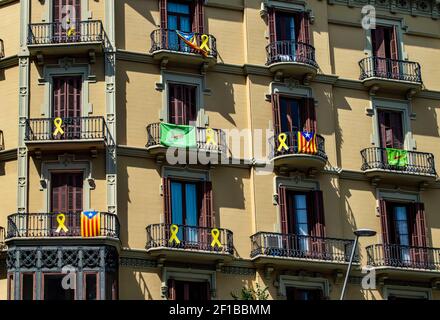 Barcellona, Spagna - 24 luglio 2019: Bandiere catalane e nastri di protesta sui balconi di un edificio nella città di Barcellona, Catalogna, Spagna Foto Stock