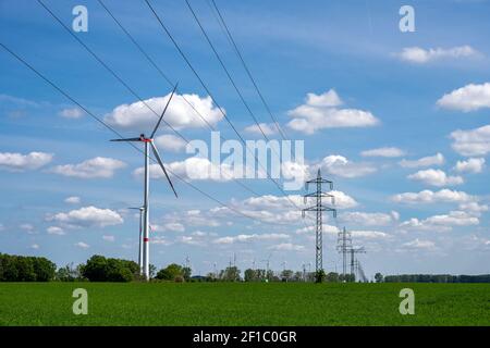 Linee elettriche aeree e turbine eoliche viste in Germania Foto Stock