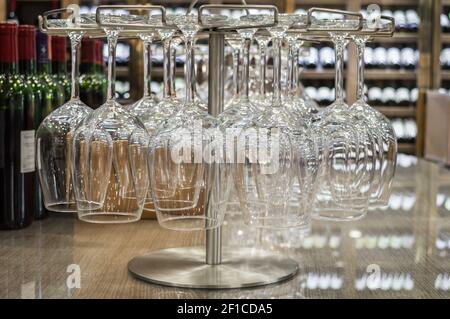 Primo piano bicchieri da vino vuoti appesi capovolti in un enoteca Foto Stock