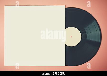 Vecchio disco in vinile retrò in custodia su sfondo rosa, mock-up. Foto con tonalità vintage Foto Stock