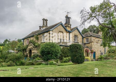 Cieli tempestosi su una proprietà indipendente costruita in pietra nel villaggio di Edensor, Derbyshire, Regno Unito Foto Stock