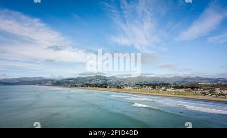 Oceano, spiaggia, surfisti e cielo blu. Foto aerea realizzata a New Brighton Beach a Christchurch, Nuova Zelanda Foto Stock