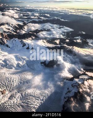 Montagne coperte di neve e protette da nuvole tiro aereo Realizzato in aereo sopra il Ghiacciaio Franz Josef nella costa occidentale Regione della Nuova Zelanda Foto Stock