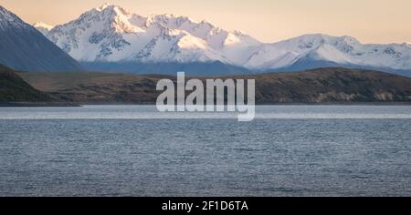 Catena montuosa durante l'alba con il lago in primo piano, girato al lago Tekapo, Nuova Zelanda Foto Stock